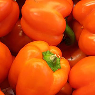 Orange bell peppers piled together (detail, upper left)